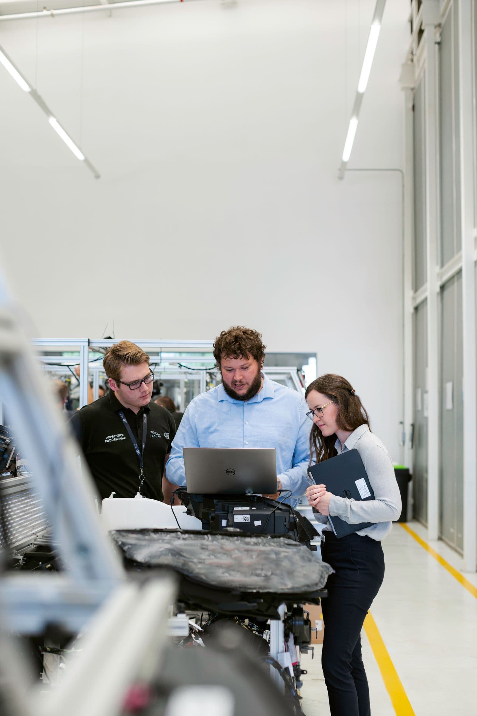 Team eines Mittelstandsbetriebs am Laptop in der Werkstatt